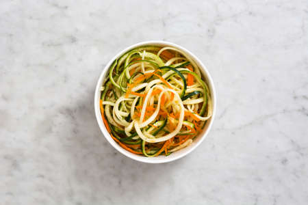 Carrot and zucchini noodles on marbleの写真素材