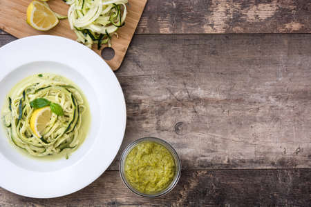 Zucchini noodles with pesto sauce on wooden backgroundの写真素材