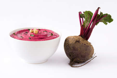 Beet hummus in a bowl isolated on white background