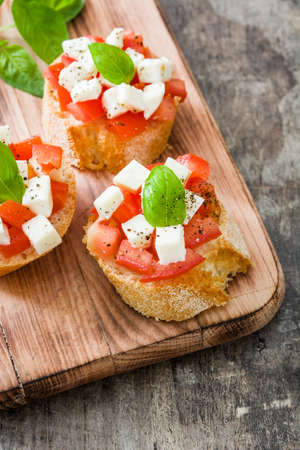 Bruschetta caprese salad on wooden table