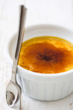 Traditional French creme brulee dessert with caramelized sugar on top, on wooden tableの写真素材