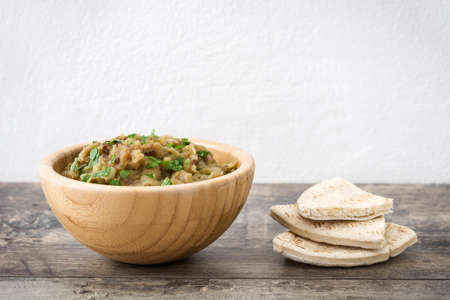 Baba Ganoush and pita bread in bowl on wooden tableの写真素材
