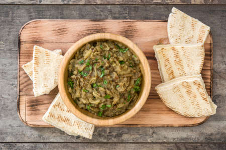 Baba Ganoush and pita bread in bowl on wooden table