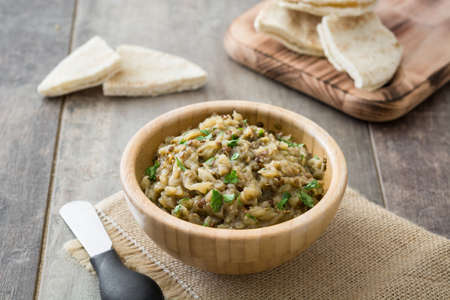 Baba Ganoush and pita bread in bowl on wooden tableの写真素材
