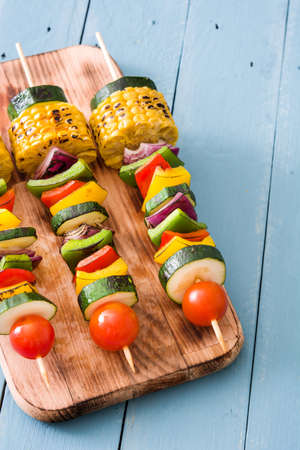 Vegetable skewers on blue wooden tableの写真素材