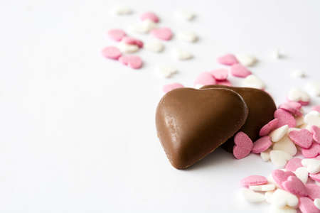 Chocolate bonbons and candies with heart shape on white background