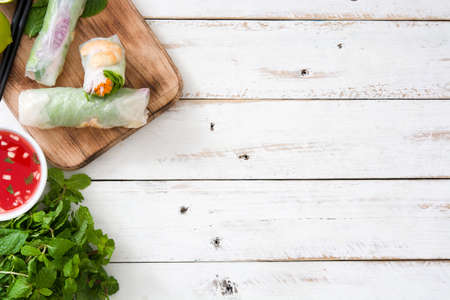 Vietnamese rolls with vegetables, rice noodles and prawns on white wooden backgroundの写真素材