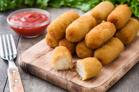 Traditional Spanish fried croquetas (croquettes) With ketchup on wooden backgroundの写真素材