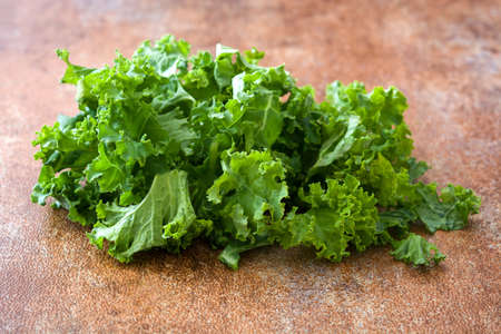 Fresh green superfood kale leaves on rusto background