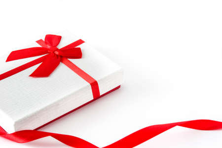 White gift box and red ribbon on white background