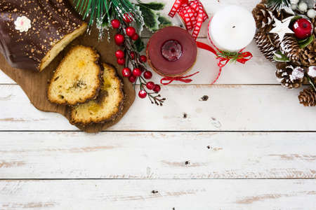 Christmas chocolate yule log cake and christmas ornament on white wooden backgroundの写真素材