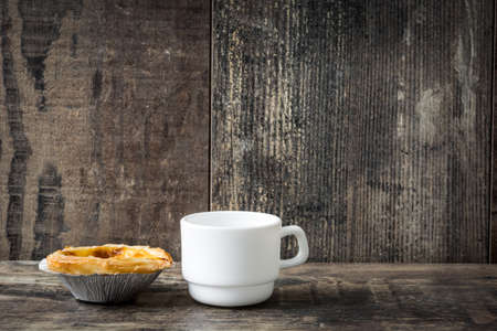 "Pasteis de nata". Typical Portuguese egg custard tart with coffee on wooden backgroundの写真素材