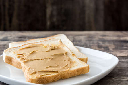 Peanut butter and toasts on wooden table. Copyspace.の写真素材
