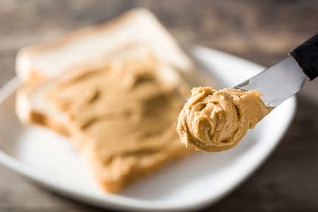 Peanut butter knife close-up With toast backgroundの写真素材