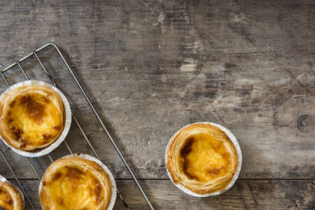 "Pasteis de nata". Typical Portuguese egg custard tart on wooden backgroundの写真素材