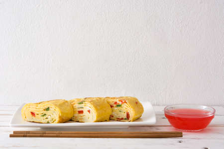 Tamagoyaki Traditional Japanese omelette on white wooden table.