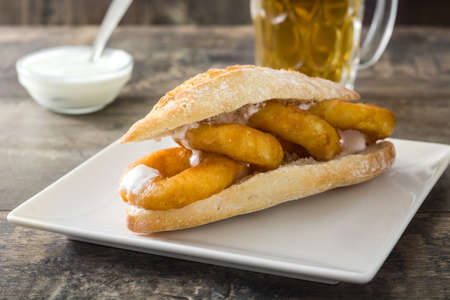 Calamari sandwich and beer on wooden tableの写真素材