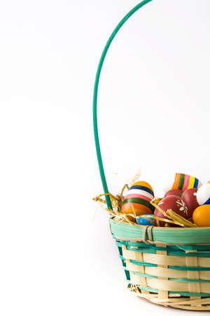 Colored easter eggs in a basket isolated on white backgroundの写真素材