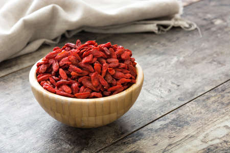 Or wolfberries Goji berries in bowl on wooden tableの写真素材