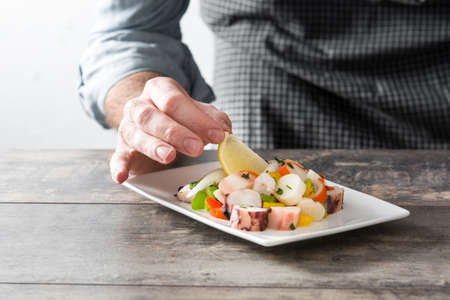 Chef preparing seafood ceviche on wooden table