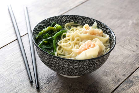 Wonton soup in a bowl on wooden table. Chinese foodの写真素材