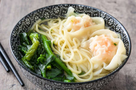 Wonton soup in a bowl on wooden table. Chinese foodの写真素材