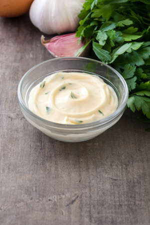 Aioli sauce and ingredients on wooden backgroundの写真素材