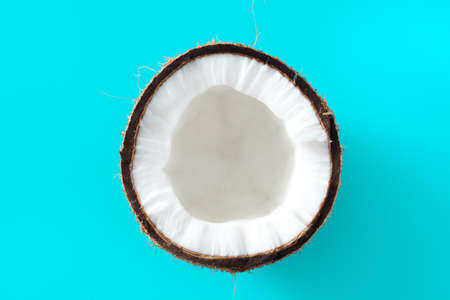 Half coconut fruit isolated on blue backgroundの写真素材