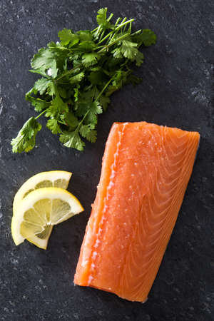 Raw salmon fillet on slate plateの写真素材