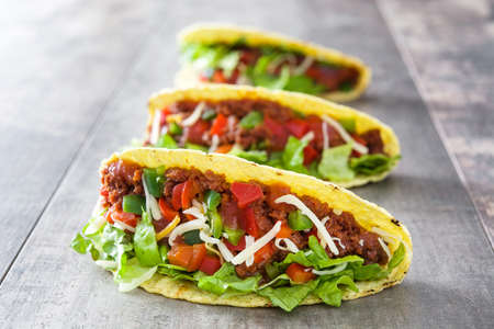 Traditional Mexican taco with meat and vegetables on wooden backgroundの写真素材