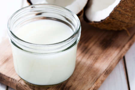 Coconut and coconut milk on white wooden table