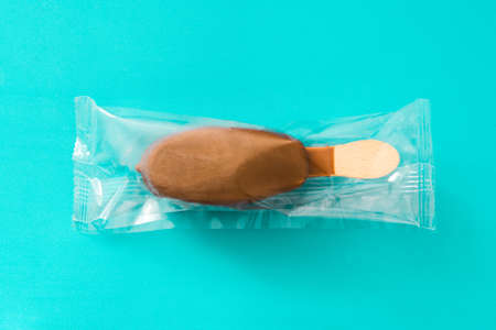 Chocolate ice cream  wrapped in plastic bag, isolated on blue background.の写真素材