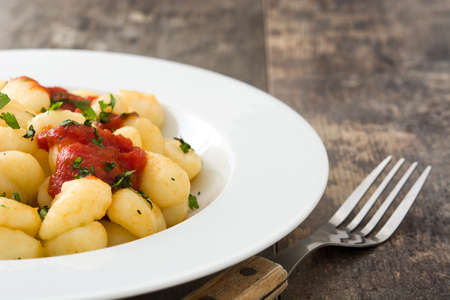 Gnocchi with tomato sauce on wooden backgroundの写真素材