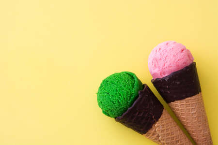 Ice cream cones on yellow backgroundの写真素材