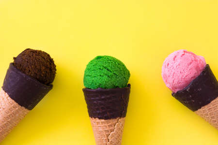 Ice cream cones on yellow backgroundの写真素材