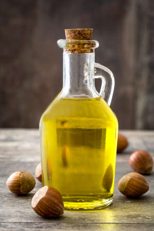 Hazelnuts oil in a bottle on wooden table backgroundの写真素材