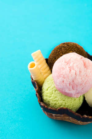 Ice cream scoops served in waffle basket on blue background