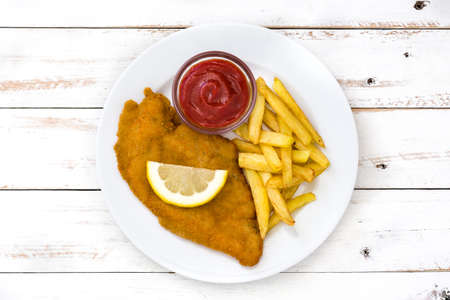 Wiener schnitzel with fried potatoes on white wooden backgroundの写真素材