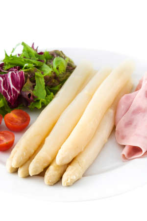 White asparagus with salad and ham isolated on white backgroundの写真素材