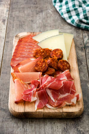 Spanish. Cheese, sausage and ham on wooden table