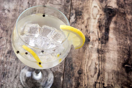 Glass of gin and tonic with lemon on wooden backgroundの写真素材