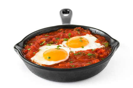 Mexican breakfast: Huevos rancheros in iron frying pan isolated on white backgroundの写真素材
