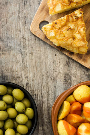 Traditional spanish tapas. Croquettes, olives, omelette, ham and patatas bravas on wooden tableの写真素材