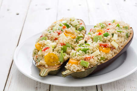 Stuffed eggplant with quinoa and vegetables on white wooden tableの写真素材