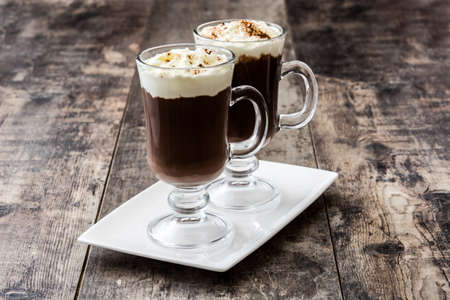 Irish coffee in glass on wooden background