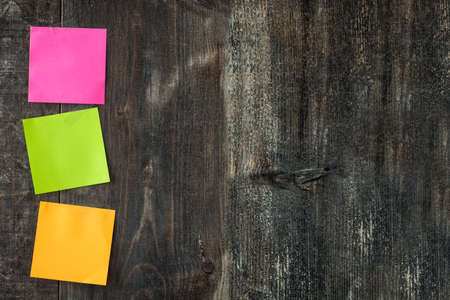 Colorful stick notes on wooden table. Copyspace.