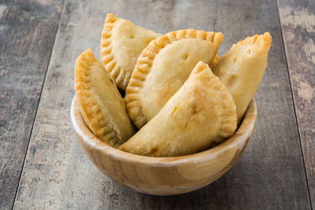 Typical Spanish empanadas in bowl on wooden tableの写真素材