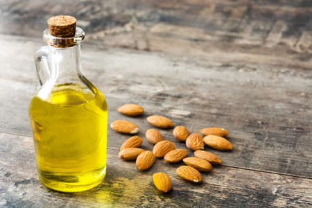 Almond oil in bottle on wooden tableの写真素材