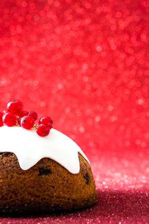 Christmas pudding on red glitter backgroundの写真素材