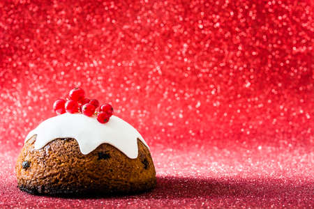 Christmas pudding on red glitter backgroundの写真素材